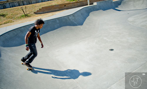 T.J. Shubert-Helton rides the lip of a bowl at Duncan Creek Skatepark in Dacula as he rides his skateboard on Thursday, March 27, 2014. 