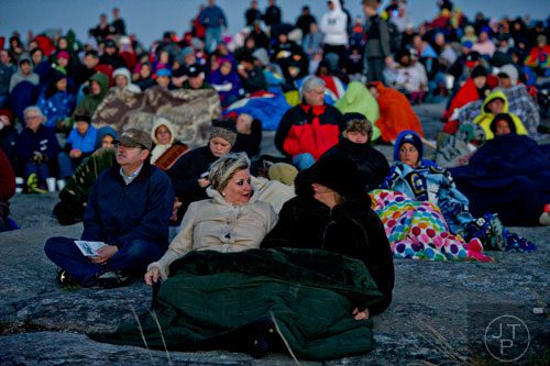 Karen Nolan (left) sits next to her twin sister Kathy Whitaker on top of Stone Mountain before the start of the 70th annual Easter Sunrise Service on Sunday, April 20, 2014.
