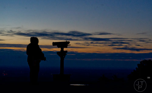 Florence Welch watches the sun rise from the top of Stone Mountain before the start of the 70th annual Easter Sunrise Service on Sunday, April 20, 2014. 