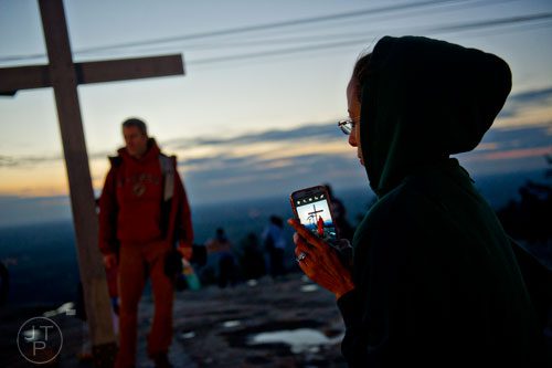 Tanisha Turner (right) waits for her turn to take a photo in front of the cross on top of Stone Mountain before the start of the 70th annual Easter Sunrise Service on Sunday, April 20, 2014. 