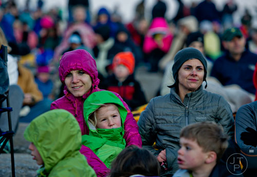  Juli Clay (left) holds her daughter Weatherly as she sits next to her friend Chevi Ferguson on top of Stone Mountain during the 70th annual Easter Sunrise Service on Sunday, April 20, 2014. 