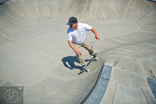 Troy Wilkas rides his skateboard in one of the bowls at the Settles Bridge Skatepark in Suwanee on Thursday, March 27, 2014. 