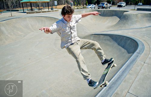 David Lamb slides along the lip of a bowl as he rides his skateboard at the Settles Bridge Skatepark in Suwanee on Thursday, March 27, 2014. 