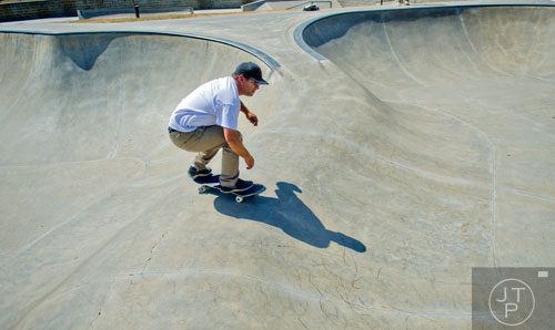 Troy Wilkas rides his skateboard in one of the bowls at the Settles Bridge Skatepark in Suwanee on Thursday, March 27, 2014.  