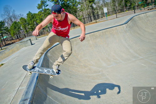 Michael Jewell slides along the lip of a bowl as he rides his skateboard at the Settles Bridge Skatepark in Suwanee on Thursday, March 27, 2014. 