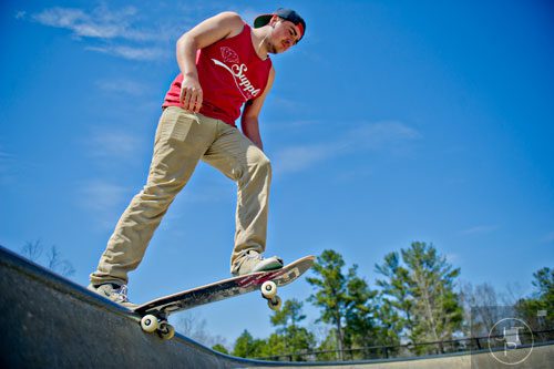 Michael Jewell hangs on the lip of a bowl as he rides his skateboard at the Settles Bridge Skatepark in Suwanee on Thursday, March 27, 2014.  