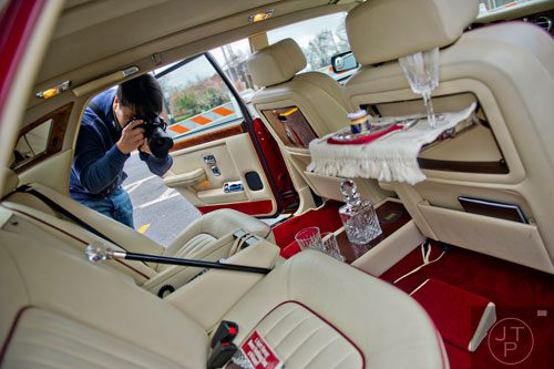 Kosit Japusripan takes a photograph of the interior of a 1978 Rolls Royce during the Great British Car Fayre in downtown Alpharetta on Saturday, March 29, 2014. 
