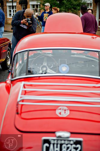 Larlon Hinton takes a photograph of a MG-A 1500 coupe during the Great British Car Fayre in downtown Alpharetta on Saturday, March 29, 2014. 