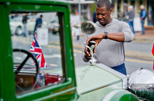Jerome Kellogg uses his phone to take a photograph of a Rolls Royce Hooper D during the Great British Car Fayre in downtown Alpharetta on Saturday, March 29, 2014. 