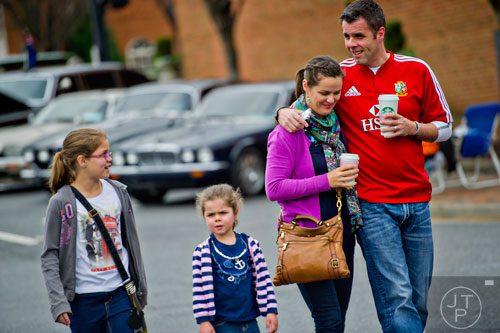 Marcus Kingsley (right) walks with his arm around his wife Emma while talking to his daughters Maisie and Molly during the Great British Car Fayre in downtown Alpharetta on Saturday, March 29, 2014. 