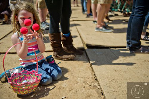 Serenity Daniel plays with clown noses while people dance around her as the Dirty Dozen Brass Band performs on stage during the Sweetwater 420 Festival at Centennial Olympic Park on Sunday, April 20, 2014.