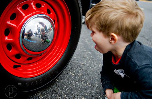 Oliver Johnson checks out his reflection in the hubcap of a 1948 Allard L Type during the Great British Car Fayre in downtown Alpharetta on Saturday, March 29, 2014. 