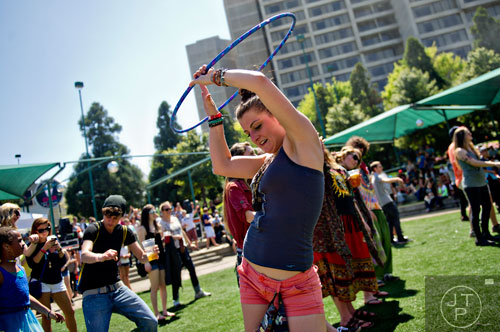 Makenzie Curtis (center) uses a hoola hoop to dance with during the Sweetwater 420 Festival at Centennial Olympic Park on Sunday, April 20, 2014. 