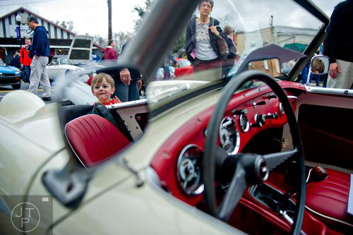 Three year old Gus Fragale (left) looks at the inside of a 1960 Austin-Healey Sprite during the Great British Car Fayre in downtown Alpharetta on Saturday, March 29, 2014. 