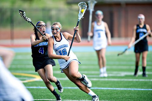 Cambridge's Taylor Sanna (16) tries to protect the ball from Lake Norman's Taylor Vaccaro (4) on Friday, April 25, 2014.