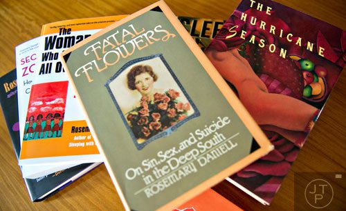 Author Rosemary Daniell's 1980 feminist memoir "Fatal Flowers: On Sin, Sex, and Suicide in the Deep South " which was named Book of the Year by Time magazine, sits on top of a stack of other books penned by Daniell. 