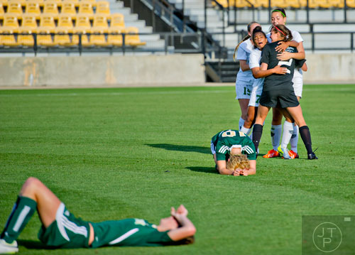 Harrison's Melissa Cameron (7) hugs goal keeper Kelsey Daugherty (2) as they celebrate their 2-1 victory over Grayson at the conclusion of the Class AAAAAA championship soccer game at Kennesaw State University on Saturday, May 17, 2014. 