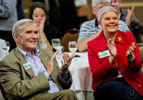 Mike Bowers (left) and his wife Bette Rose clap for Karen Handel as she speaks to friends and supporters during her election party at the Double Tree Hotel in Roswell on Tuesday, May 20, 2014. 