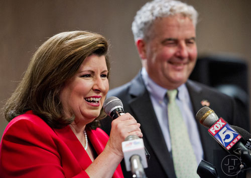Backed by her husband Steve (right), Karen Handel speaks to friends and supporters during her election party at the Double Tree Hotel in Roswell on Tuesday, May 20, 2014. 