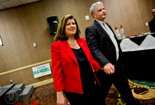 Karen Handel (left) walks away from the podium hand in hand with her husband Steve after missing out on a runoff position for the U.S. Senate at the Double Tree Hotel in Roswell on Tuesday, May 20, 2014.     