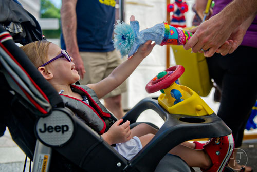 Molly McDonnell (left) laughs as her father Bobby shows her a puppet during the May-retta Daze Arts & Craft Festival at Glover Park in Marietta on Sunday, May 4, 2014.