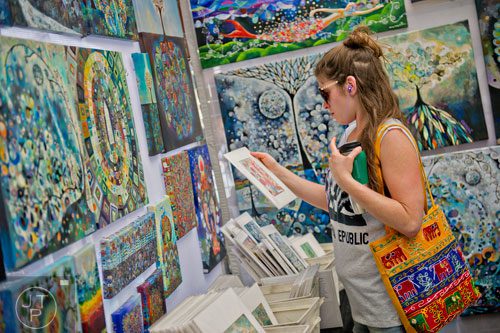 A woman looks at paintings in Manami Lingerfelt's booth during the May-retta Daze Arts & Craft Festival at Glover Park in Marietta on Sunday, May 4, 2014. 