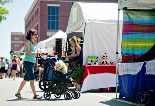 Sherry Jacques (left) pushes her havanese poodle Prince in a stroller as she walks the artist booths during the May-retta Daze Arts & Craft Festival at Glover Park in Marietta on Sunday, May 4, 2014. 