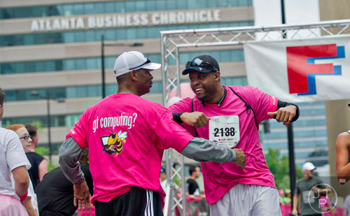 Troy Peace (left) gives Anthony McCoy a hug as he crosses the finish line for the Susan G. Komen Race for the Cure at Lenox Square Mall on Saturday, May 10, 2014. 