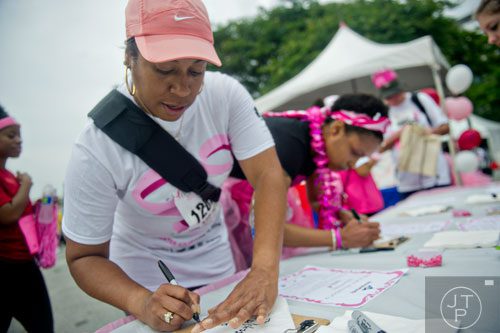 Rachelle Savage writes a message of hope for her second mother Phyllis Pete Johns after the Susan G. Komen Race for the Cure at Lenox Square Mall on Saturday, May 10, 2014. 