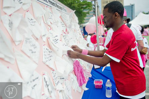 Drake Kenon pins a message of hope to a bulletin board in honor of his mother Brendene after the Susan G. Komen Race for the Cure at Lenox Square Mall on Saturday, May 10, 2014. O