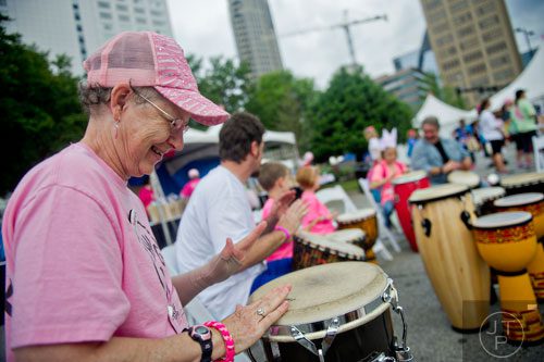 Margaret Leeper (left) bangs on a drum after the Susan G. Komen Race for the Cure at Lenox Square Mall on Saturday, May 10, 2014. 