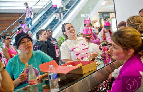 Tricia Ziem (center) laughs while eating a celebratory cupcake with friends after the Susan G. Komen Race for the Cure at Lenox Square Mall on Saturday, May 10, 2014. 