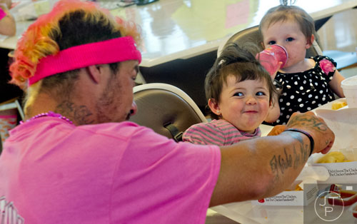 Harmony Wilson (center) gives her father Craig a funny look as they eat lunch after the Susan G. Komen Race for the Cure at Lenox Square Mall on Saturday, May 10, 2014. 