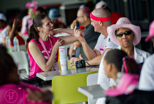 Anthony Lane (right) shows his wife Kandi a photo on his phone after the Susan G. Komen Race for the Cure at Lenox Square Mall on Saturday, May 10, 2014. 