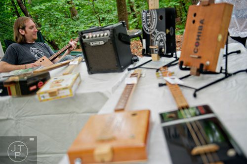 Artist Mike Snowden plays one of his cigar box guitars at his booth during the Buckhead Spring Arts & Crafts Festival at Chastain Park in Atlanta on Saturday, May 10, 2014. 