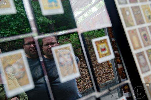 John Pommer looks at drawings by artist Kevin Lahvic during the Buckhead Spring Arts & Crafts Festival at Chastain Park in Atlanta on Saturday, May 10, 2014. 