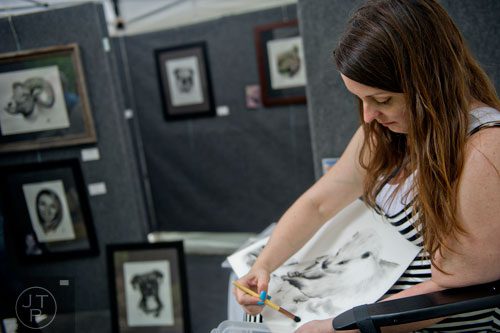 Artist Amy Jones Miller works on a charcoal drawing of a beaver in her booth during the Buckhead Spring Arts & Crafts Festival at Chastain Park in Atlanta on Saturday, May 10, 2014. 