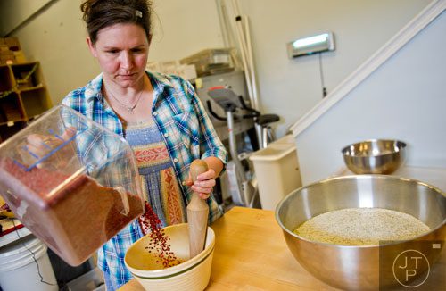 Suzi Sheffield pours fresh red peppercorns into a bowl as she prepares to mix them with salt at Beautiful Briny Sea in the Old Fourth Ward neighborhood of Atlanta on Wednesday, May 14, 2014.   