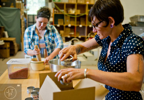 Charlie Graham (right) and Suzi Sheffield make containers of flavor infused salt at Beautiful Briny Sea in the Old Fourth Ward neighborhood of Atlanta on Wednesday, May 14, 2014.   