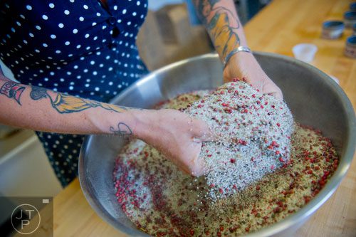 Charlie Graham mixes fresh ingredients with salt in a bowl at Beautiful Briny Sea in the Old Fourth Ward neighborhood of Atlanta on Wednesday, May 14, 2014.  