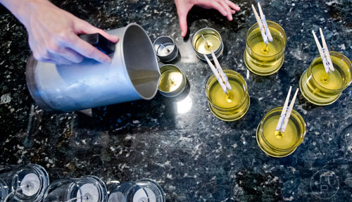 Adair Cates pours melted wax into glass jars as she makes candles for Yo Soy Candles at her home in Midtown, Atlanta on Thursday, May 15, 2014.  
