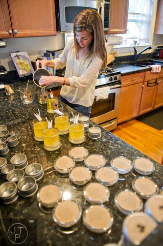 Adair Cates pours melted wax into glass jars as she makes candles for Yo Soy Candles at her home in Midtown, Atlanta on Thursday, May 15, 2014. 