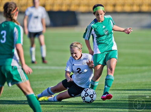 McIntosh's Anna Brachey (right) keeps the ball away from Starr's Mill's Sarah Yoss (2) as she falls to the field during the Class AAAAA championship game at Kennesaw State University on Friday, May 16, 2014.   