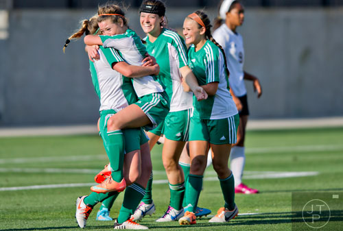 McIntosh's Amanda Bartholomew (left) lifts Rachel Green into the air as they and teammates Jackie Gray and Annie Yokaris celebrates the team's fourth goal of their game against Starr's Mill during the Class AAAAA championship game at Kennesaw State University on Friday, May 16, 2014.