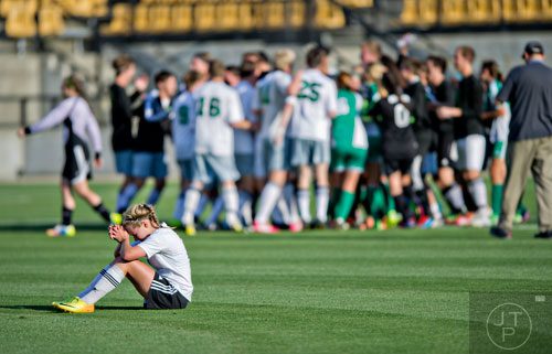Starr's Mill's Sarah Yoss (left) sits on the field with her head in her hands after losing to McIntosh 4-1 in the Class AAAAA championship game at Kennesaw State University on Friday, May 16, 2014.   