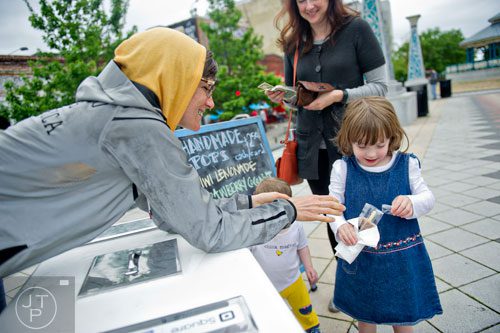 Charlie Graham (left) hands Finna Barker a popsicle as she walks the square with her mother Shannon in downtown Decatur on Wednesday, April 30, 2014.    