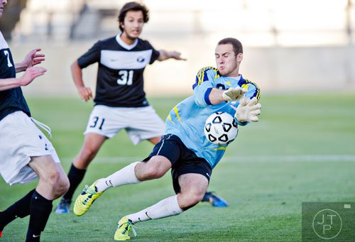 Houston County goalie Bryce Dawson (center) lets the ball get past him on a kick by McIntosh's Adam Sheikali during the Class AAAAA championship game at Kennesaw State University on Friday, May 16, 2014.