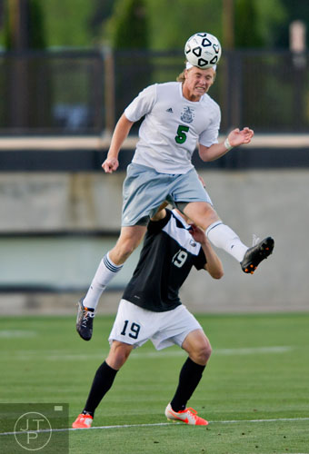 McIntosh's Nicholas Alvey (5) beats out Houston County's Sean Smith (19) for the header during the Class AAAAA championship game at Kennesaw State University on Friday, May 16, 2014. 