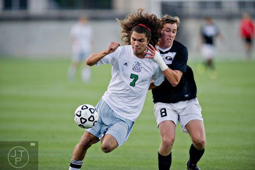 McIntosh's Didrik Cooper-Seip (7) keeps the ball away from Houston County's Will Pospisil (8) as they move up the field during the Class AAAAA championship game at Kennesaw State University on Friday, May 16, 2014. 