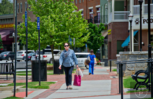 Anita Smith carries bags to her car after finishing shopping in downtown Suwanee on Thursday, May 1, 2014.  